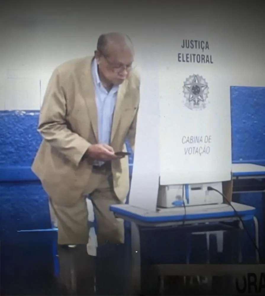 Ministro Gilmar Mendes é flagrado com celular na cabine, prática proibida pela Justiça Eleitoral